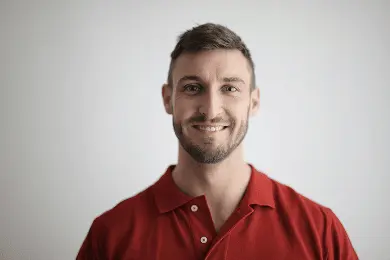 A heashot photo of our team member Dr. Matt Jennings, smiling in a red polo shirt.