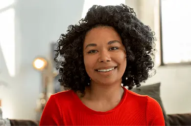 A heashot photo of our team member Alicia Torres, smiling in a red tee shirt.